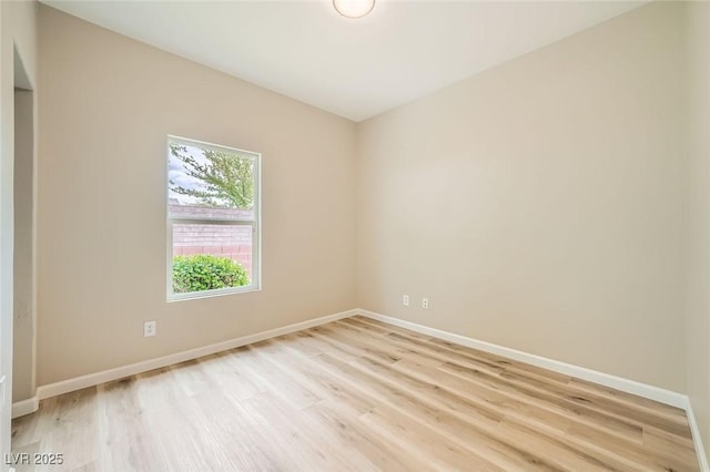 empty room with baseboards and light wood-style flooring
