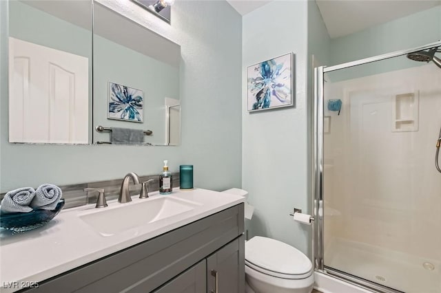 full bath featuring vanity, toilet, and a stall shower