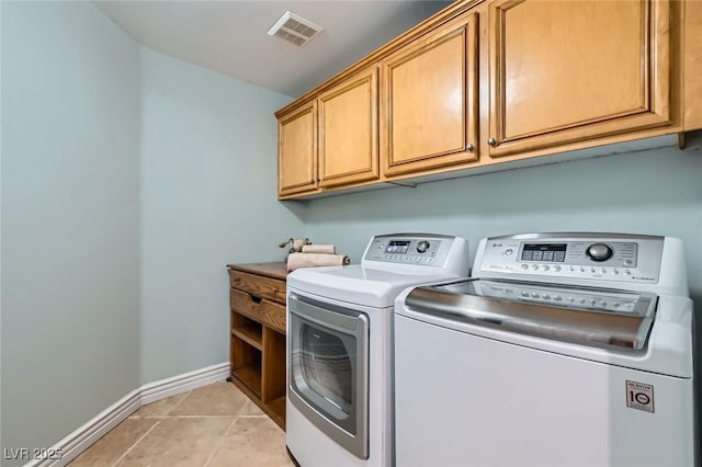 clothes washing area featuring visible vents, cabinet space, baseboards, light tile patterned flooring, and washer and clothes dryer