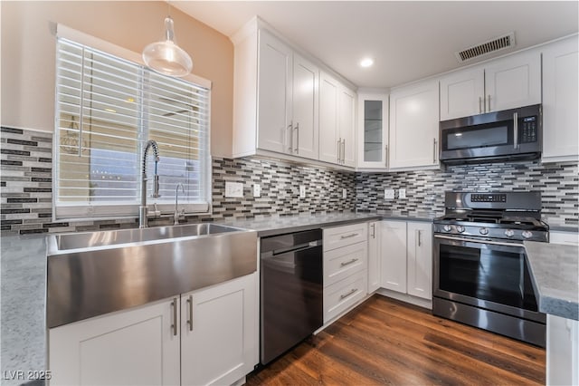 kitchen with a sink, appliances with stainless steel finishes, white cabinetry, and visible vents