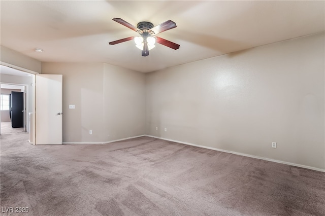 carpeted empty room with baseboards and a ceiling fan