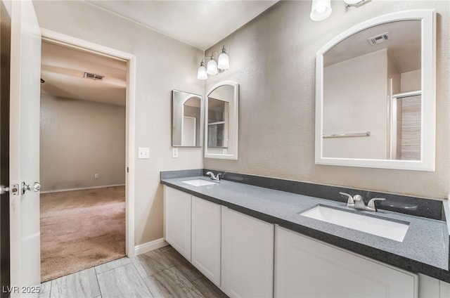 bathroom featuring double vanity, visible vents, a sink, and marble finish floor
