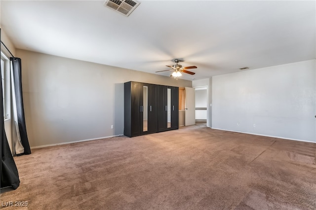 unfurnished bedroom with baseboards, carpet, a ceiling fan, and visible vents