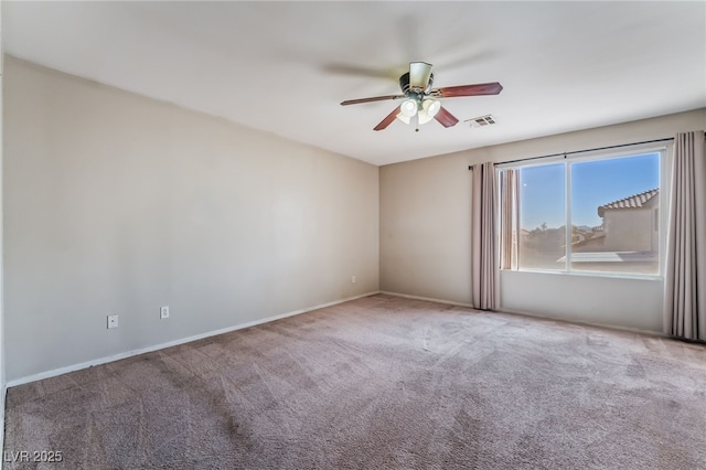 carpeted empty room featuring visible vents, baseboards, and ceiling fan