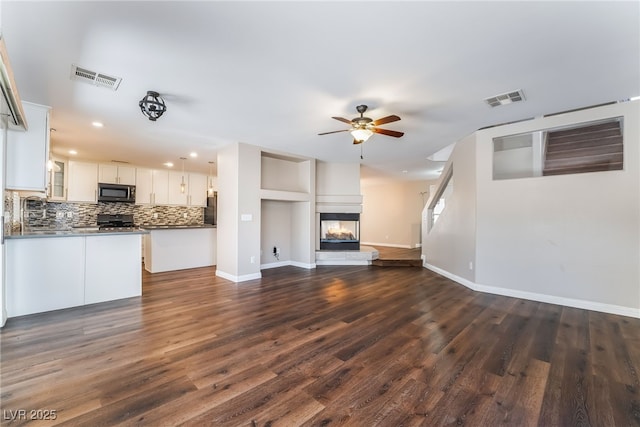 unfurnished living room with visible vents, recessed lighting, dark wood finished floors, and ceiling fan