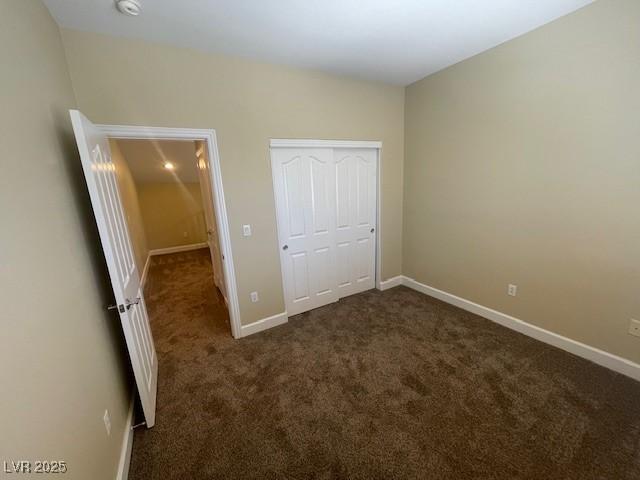 137 Coronation Ave, Las Vegas, NV 89123 - unfurnished bedroom with baseboards, a closet, and dark carpet