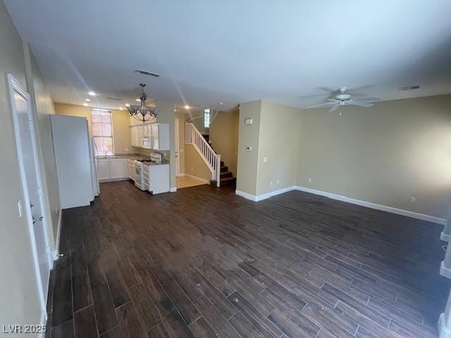 137 Coronation Ave, Las Vegas, NV 89123 - unfurnished living room with baseboards, ceiling fan with notable chandelier, stairway, and dark wood-type flooring