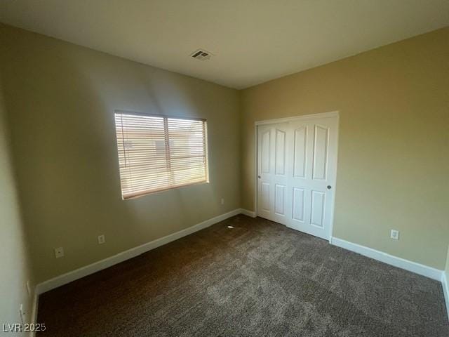 137 Coronation Ave, Las Vegas, NV 89123 - unfurnished bedroom featuring dark colored carpet, baseboards, visible vents, and a closet