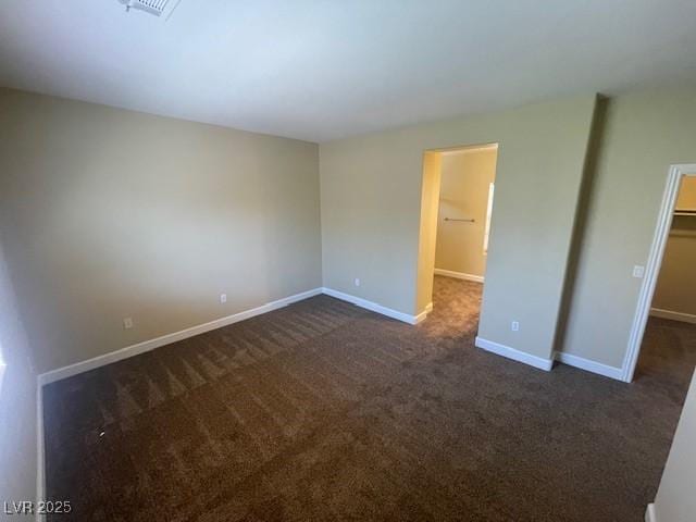 137 Coronation Ave, Las Vegas, NV 89123 - unfurnished bedroom with dark carpet, baseboards, a walk in closet, and a closet