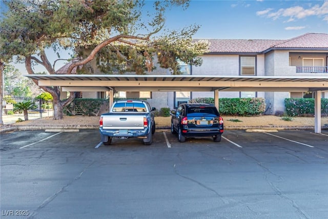 covered parking lot featuring fence