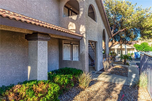 view of home's exterior with fence and stucco siding