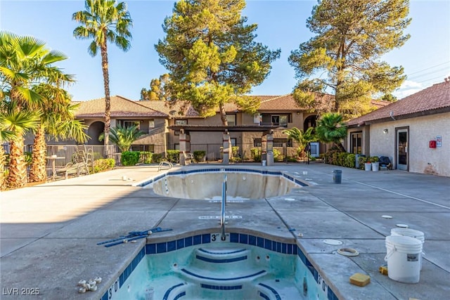 community pool with fence and a community hot tub