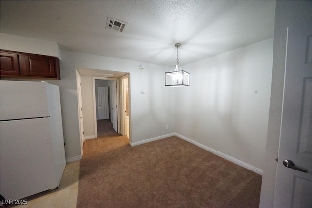 unfurnished dining area featuring light colored carpet, baseboards, and visible vents