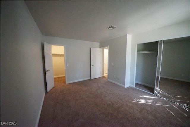 unfurnished bedroom featuring visible vents, baseboards, carpet floors, and a closet