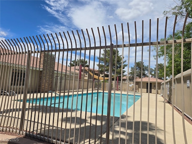 pool featuring fence and a patio area