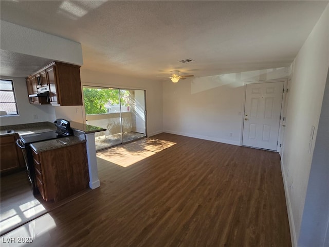 kitchen with dark wood-style flooring, electric range, a textured ceiling, and visible vents