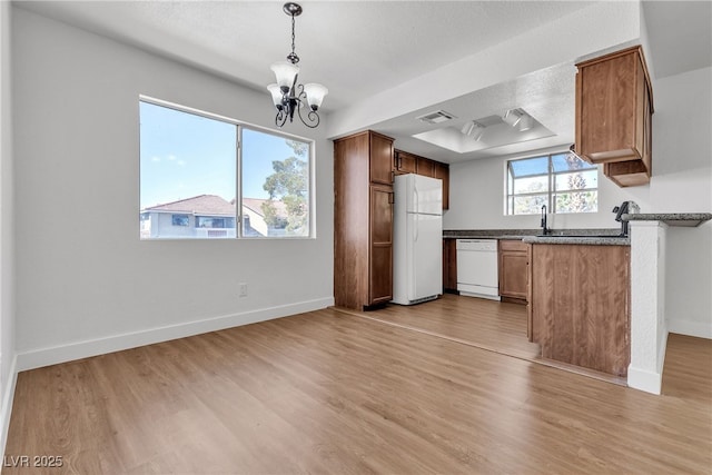 7200 Pirates Cove Rd Unit 2025, Las Vegas, NV 89145 - kitchen featuring white appliances, dark countertops, light wood-style floors, a chandelier, and baseboards