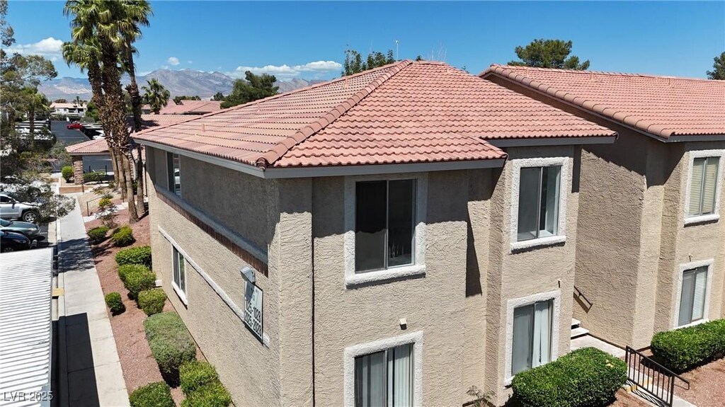 7200 Pirates Cove Rd Unit 2025, Las Vegas, NV 89145 - view of property exterior with stucco siding, a tiled roof, and a mountain view