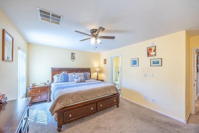 carpeted bedroom featuring baseboards, ceiling fan, ensuite bath, and visible vents