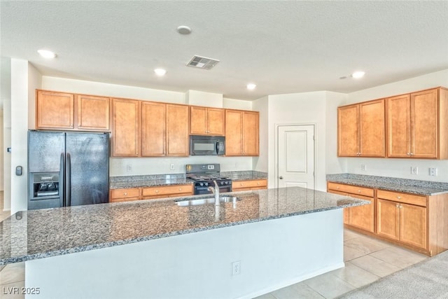 156 Fulgora St, Henderson, NV 89074 - kitchen with a sink, an island with sink, dark stone countertops, visible vents, and black appliances
