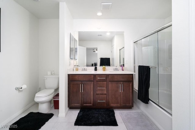 bathroom with a sink, tile patterned floors, toilet, and double vanity