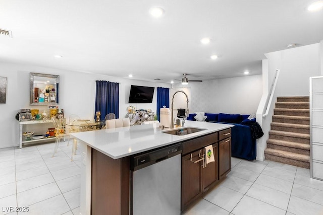 kitchen with stainless steel dishwasher, light tile patterned flooring, open floor plan, and a sink