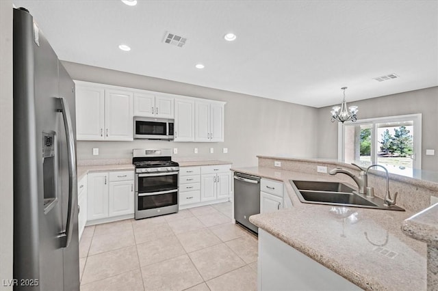 2525 Willow Wren Dr, North Las Vegas, NV 89084 - kitchen with stainless steel appliances, a sink, a chandelier, white cabinetry, and recessed lighting