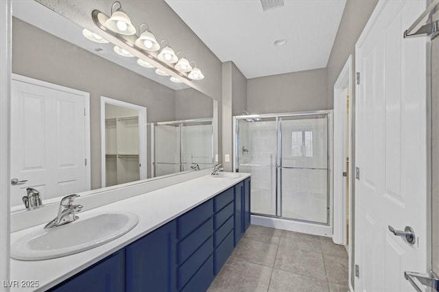 2525 Willow Wren Dr, North Las Vegas, NV 89084 - bathroom featuring a shower stall, double vanity, and tile patterned flooring