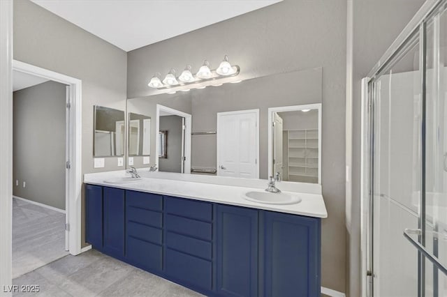 2525 Willow Wren Dr, North Las Vegas, NV 89084 - bathroom featuring double vanity, baseboards, a walk in closet, and tile patterned floors