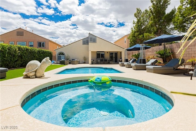 view of pool featuring a fenced in pool, a patio area, fence, and a jacuzzi