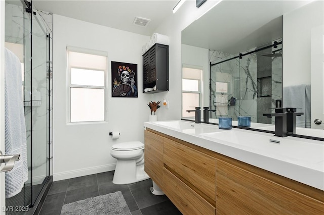 bathroom featuring toilet, a sink, visible vents, and a wealth of natural light