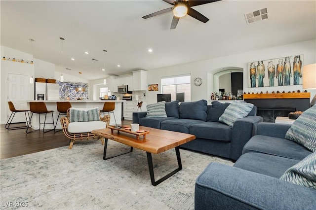 living room with a ceiling fan, visible vents, light wood-style flooring, and recessed lighting