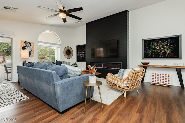 living room featuring wood finished floors, plenty of natural light, ceiling fan, and visible vents