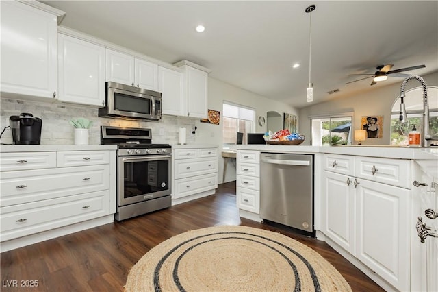 kitchen with light countertops, backsplash, white cabinets, and stainless steel appliances