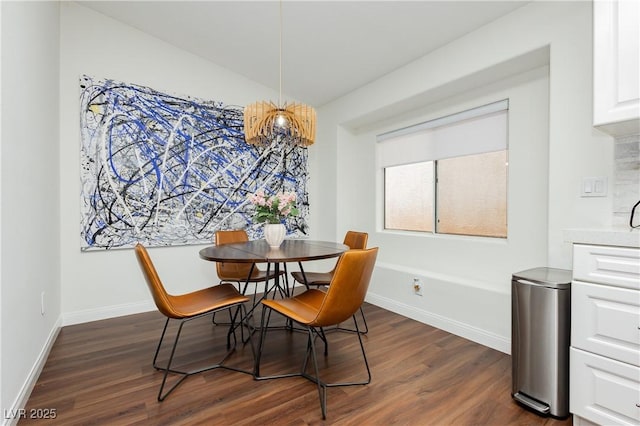 dining space featuring baseboards, a chandelier, and dark wood-type flooring
