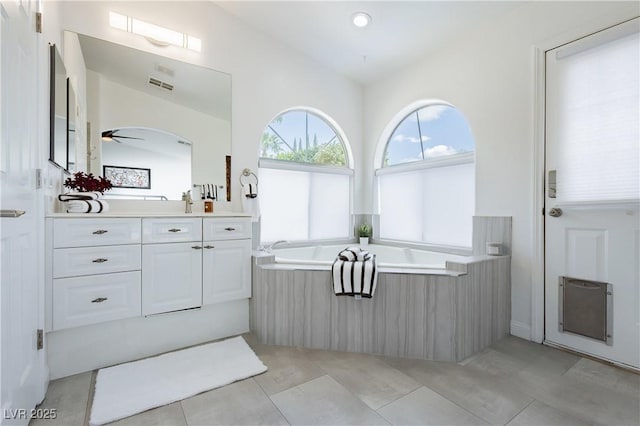 bathroom featuring visible vents, vanity, tile patterned floors, a bath, and a ceiling fan