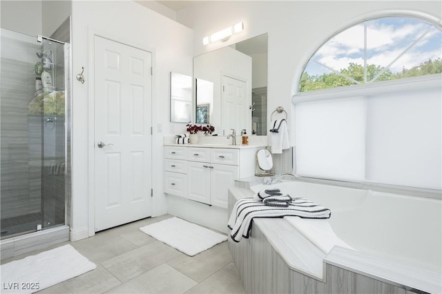 bathroom featuring tile patterned flooring, a shower stall, a garden tub, and vanity