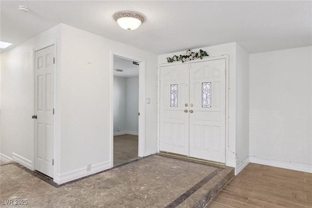 entryway featuring baseboards and wood finished floors