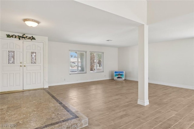 entryway featuring baseboards and wood finished floors