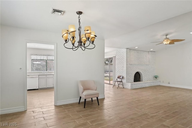 living area featuring baseboards, visible vents, light wood finished floors, and a fireplace