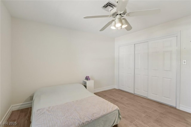 bedroom with visible vents, baseboards, and wood finished floors