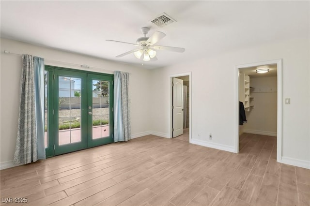 unfurnished room with light wood-style floors, baseboards, french doors, and visible vents