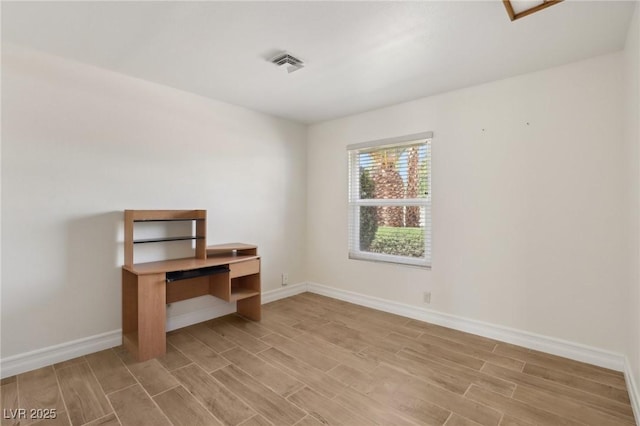 unfurnished office featuring wood tiled floor, baseboards, and visible vents
