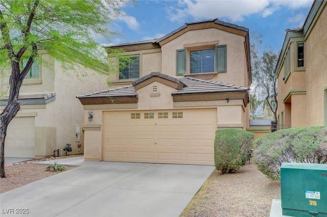 view of front of property with stucco siding, concrete driveway, a tile roof, and a garage