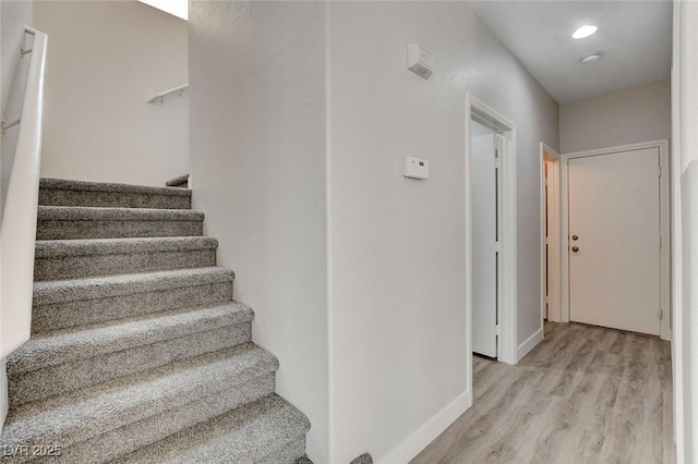 stairs with recessed lighting, baseboards, and wood finished floors