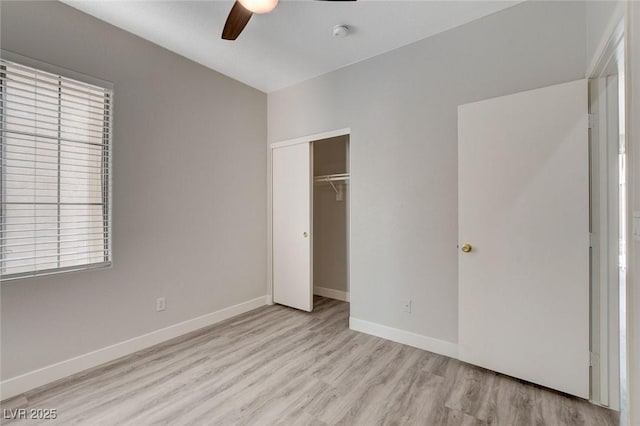 unfurnished bedroom featuring a ceiling fan, baseboards, wood finished floors, and a closet