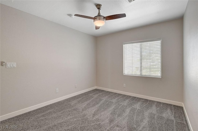 empty room featuring baseboards, a ceiling fan, and carpet