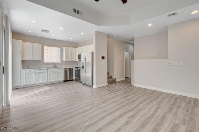 kitchen featuring visible vents, open floor plan, light wood-style flooring, and appliances with stainless steel finishes