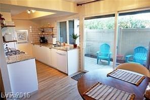 kitchen featuring white dishwasher, light wood finished floors, white cabinets, and light countertops