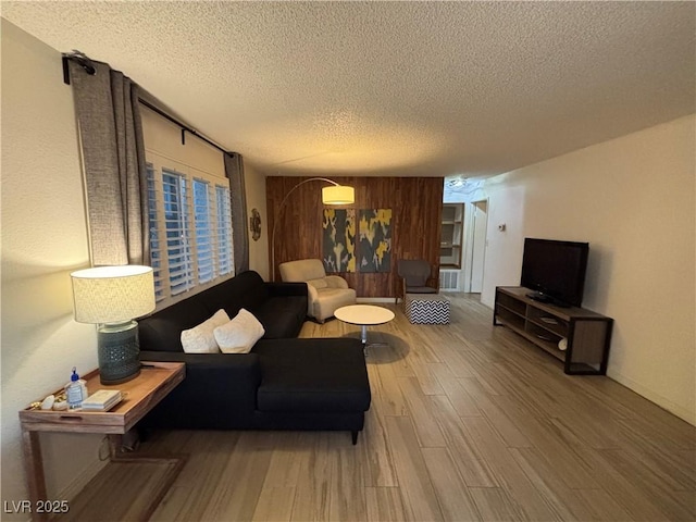 living area featuring a textured ceiling and wood finished floors